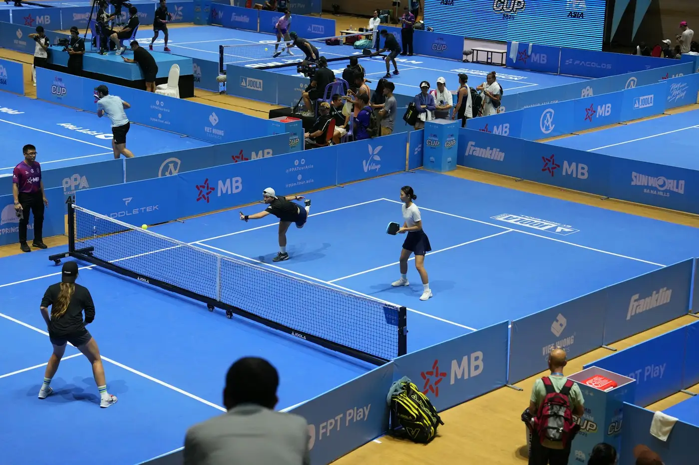 Padelspeler slaat de bal op een baan met glazen wanden