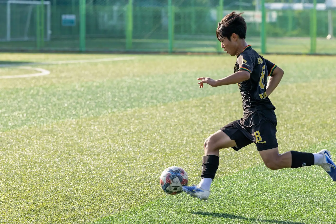 Voetballer gaat er op volle snelheid vandoor met de bal